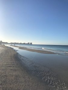 a sandy beach next to a body of water